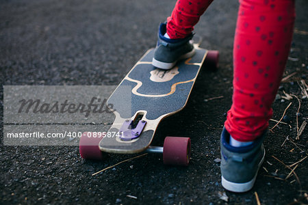 longboard on the road with teenage close up