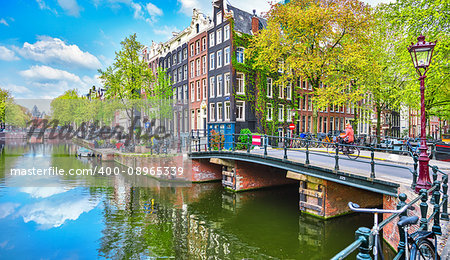 Bridge over channel in Amsterdam Netherlands houses river Amstel landmark old european city spring landscape.