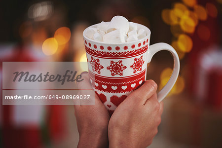 Woman holding hot chocolate in festive mug