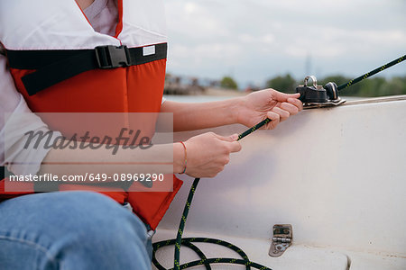 Woman on sailing boat, steering boat, close-up