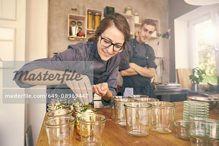 Chef filling plastic containers with portions of food