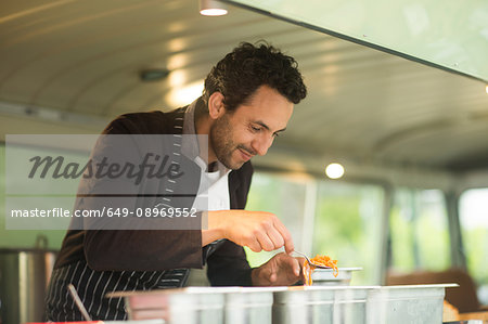 Small business owner serving food from van food stall hatch