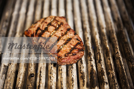 Close up high angle view of a steak on a griddle.