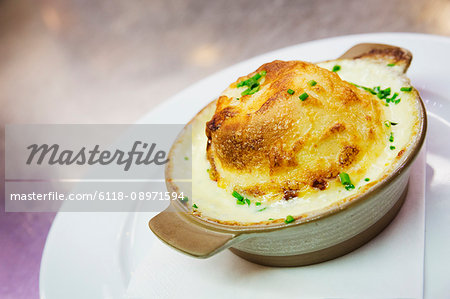 Close up of a cheese souffle in a ramekin.