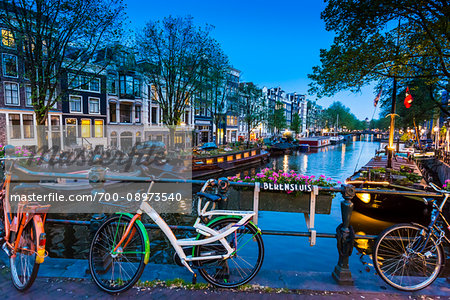 Bicycles parked along the Berensluis bridge at the Keizersgracht canal at dusk in Amsterdam, Holland Bicycles parked along the Berensluis bridge at the Keizersgracht canal at dusk in Amsterdam, Holland