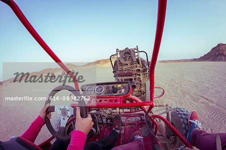 Personal perspective view of two people driving beach buggy in desert, Hurghada, Al Bahr al Ahmar, Egypt