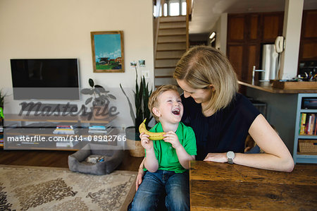 Boy sitting on mother's lap laughing