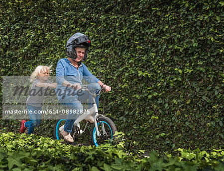 Grandson pushing grandmother on his bicycle