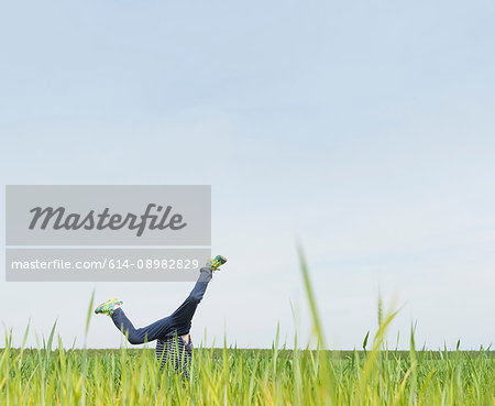 Boy cartwheeling in grass