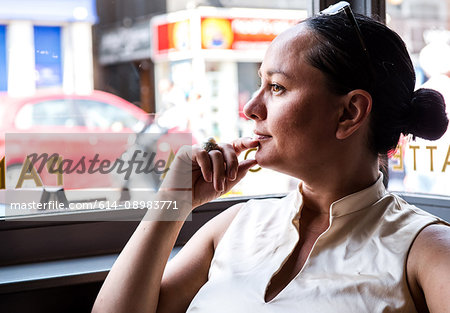 Businesswoman with hand on chin in coffee bar