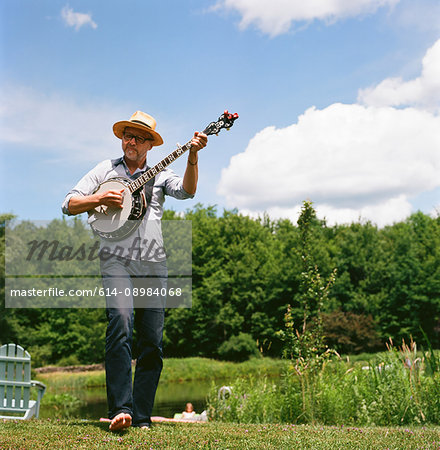 Mature man, outdoors, playing banjo