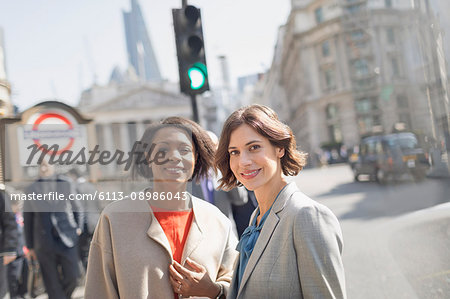 Portrait smiling, confident businesswomen on sunny urban city street, London, UK