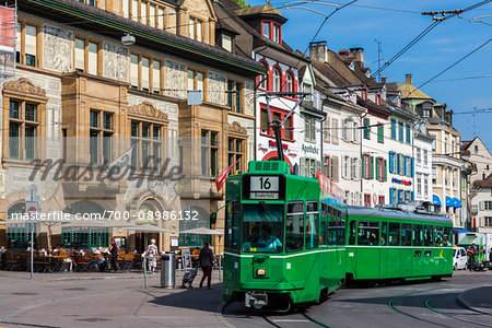 Street scene with typical buidlings and a green tram car in Basel, Switzerland