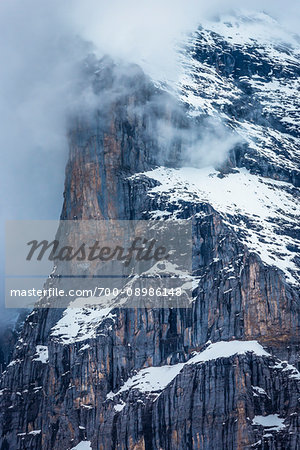 Close-up of a snow coverd cliff face with fog on a mountain top in the Jungfrau Region of the Bernese Oberland in Switzerland