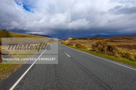 Country road with dramatic clouds in springtime on the Isle of Skye in Scotland, United Kingdom