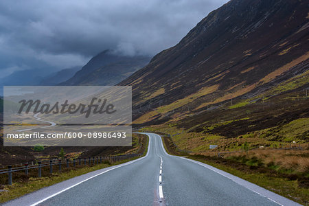 Storm clouds and typical Scottish country road through the highlands, Scotland, United Kingdom