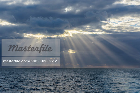 Crepuscular sunrays shining through the clouds over the North Sea, United Kingdom