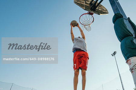 Man jumping for basketball hoop