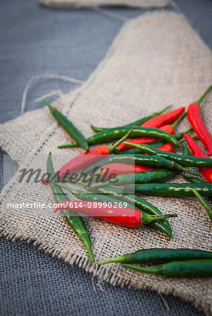 Still life of red and green chilli peppers on fabric