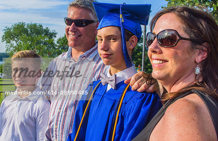 Portrait of teenage boy, with family, on his graduation day