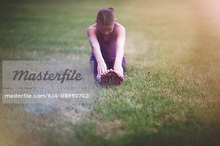Girl stretching on grass