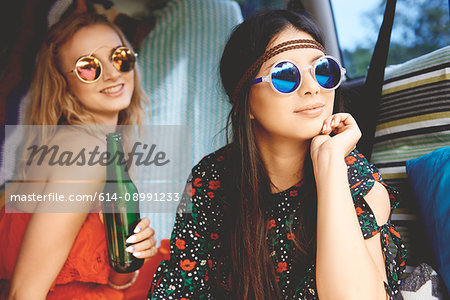 Two young boho women wearing sunglasses in recreational van