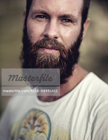 Portrait of bearded man wearing printed T-Shirt, looking at camera.