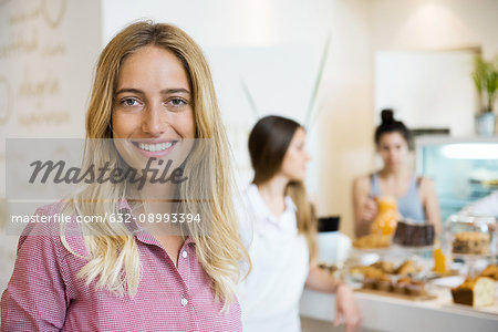 Young woman smiling cheerfully in small business, portrait