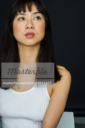 Young woman looking up in thought, portrait