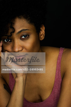 Young woman resting chin on hand, portrait