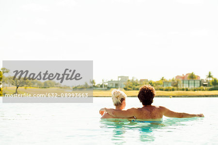 Couple relaxing together in lake, rear view