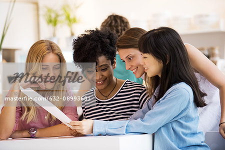 Group of friends looking at menu together in cafe