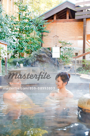 Caucasian woman with Japanese friend bathing at traditional hot spring, Tokyo, Japan