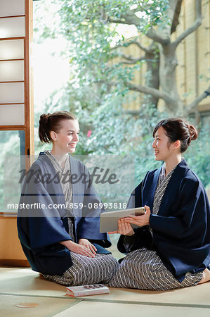 Caucasian woman wearing yukata with Japanese friend at traditional ryokan, Tokyo, Japan