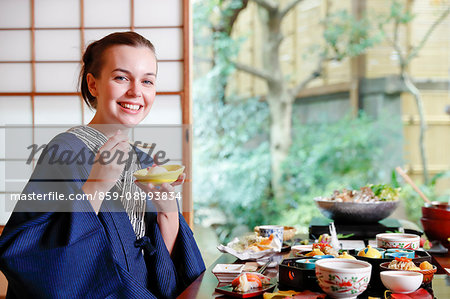 Caucasian woman wearing yukata eating at traditional ryokan, Tokyo, Japan