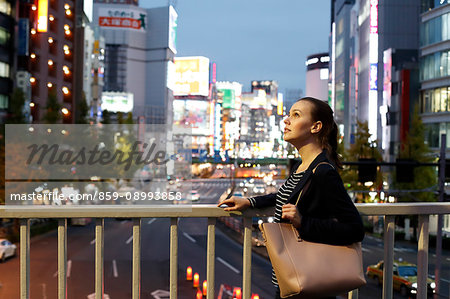 Caucasian woman downtown Tokyo at night, Tokyo, Japan