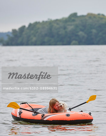 Girl with dog on inflatable boat