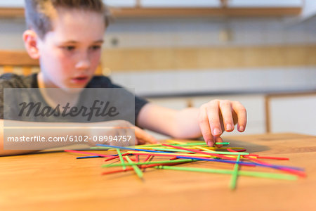 Boy playing jackstraws