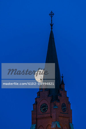 Full moon behind church tower