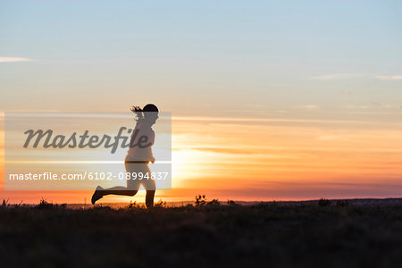 Woman running at sunset