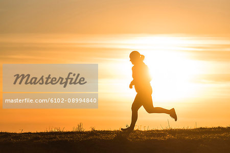 Woman running at sunset