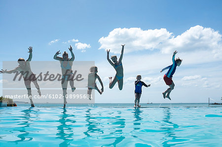 Family jumping into swimming-pool