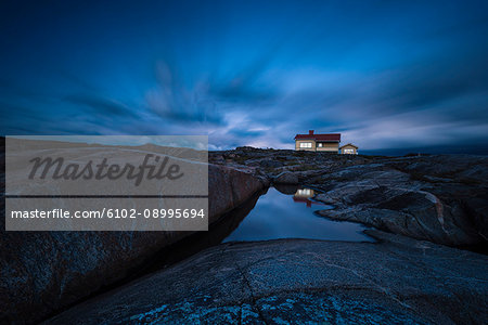 House on rocky coast at twilight