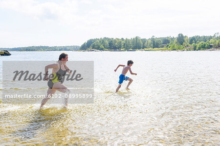 Mother running with son in lake