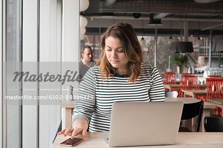 Woman in cafe using cell phone