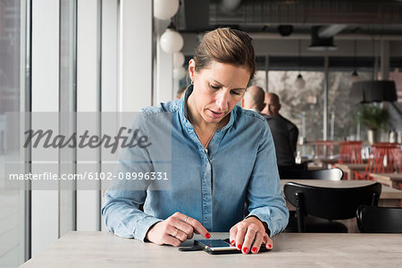 Woman in cafe using cell phone