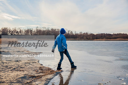 Boy playing at frozen lake