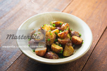 Freshly oven roasted baby potatoes with skin on wooden table