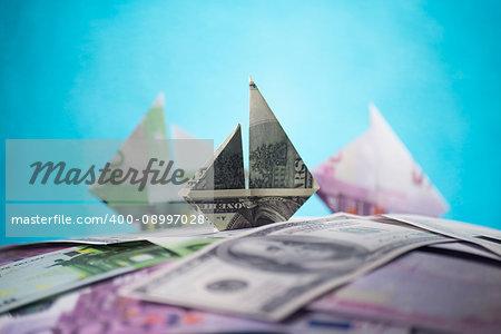ship origami banknotes on a background of money