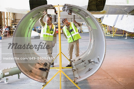Aircraft workers checking airplane part